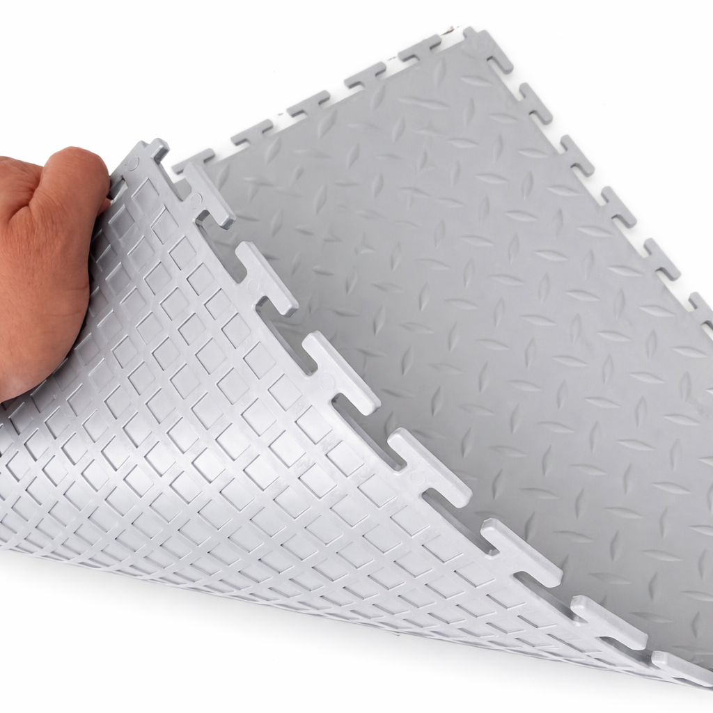 Gray interlocking foam mats with a hand holding one corner on a white background